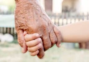 Grandchild holding grandparent for the hand,selective focus